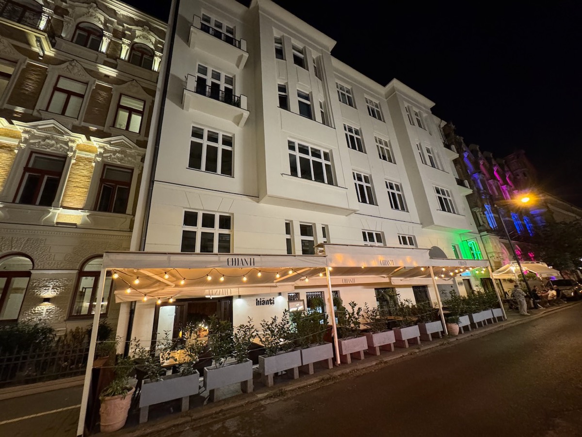 Historic 1913 tenement facade at Foksal 17 by night, restaurant terrace below